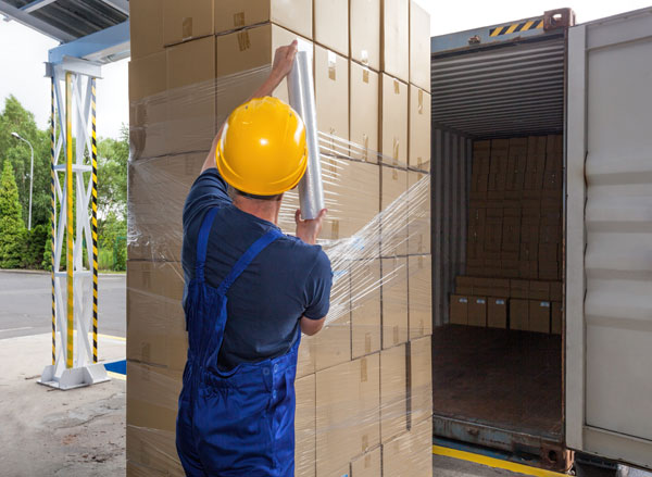 Manual pallet wrapping in action